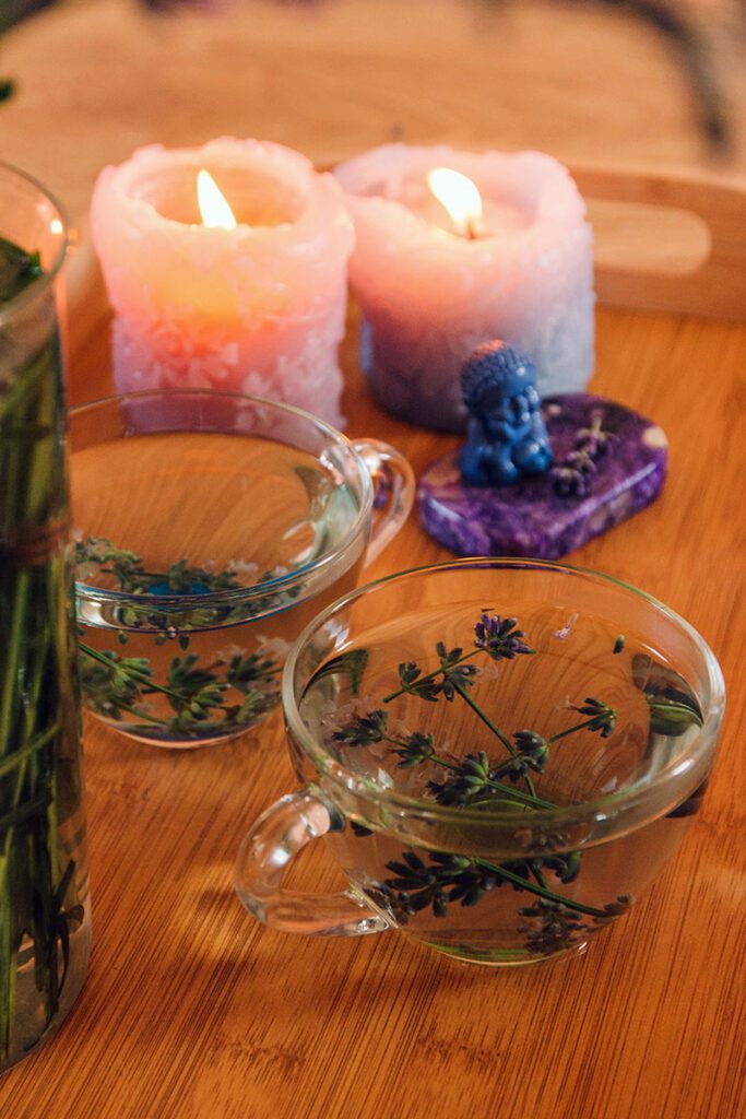 lit candles and cups of lavender aromatherpy oils